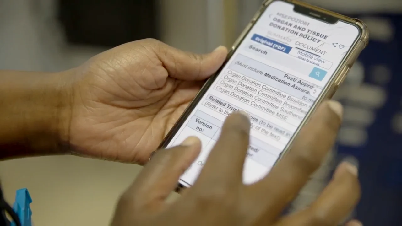 A member of staff scrolling the Organ and Tissue Donation Policy in the MyStaff app on their phone